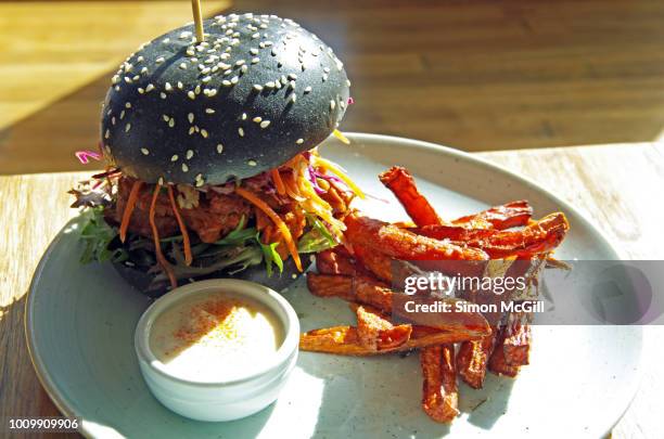 vegetarian burger with slow cooked pulled jackfruit, barbeque sauce, asian coleslaw, and pickled gerkins served with sweet potato chips - veggie burger fotografías e imágenes de stock