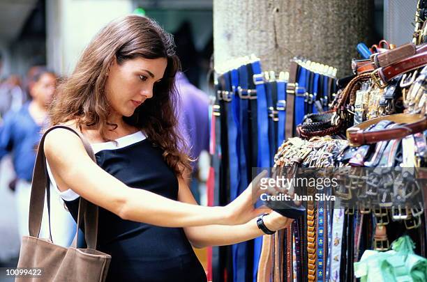 latin woman looks at belts in caracas, venezuela - caracas venezuela stock pictures, royalty-free photos & images