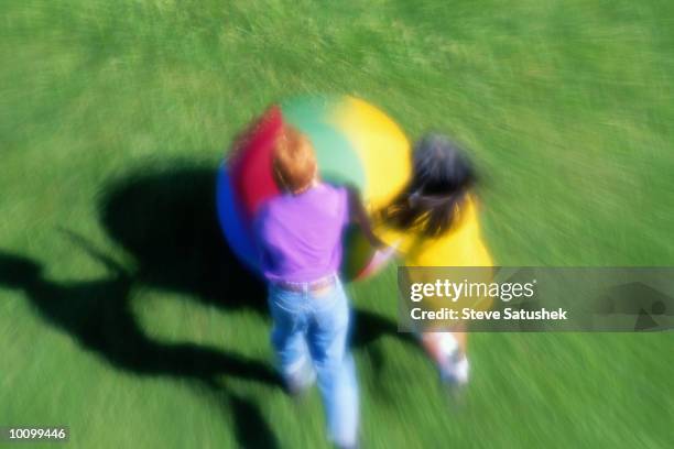 boy and girl playing with big ball - girl rolling grass stock pictures, royalty-free photos & images