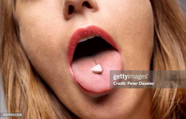 girl with recreation drug on tongue - drug addict stock-fotos und bilder