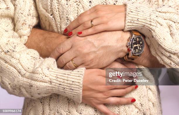husbands arms around pregnant wife's waist - human fertility stock-fotos und bilder
