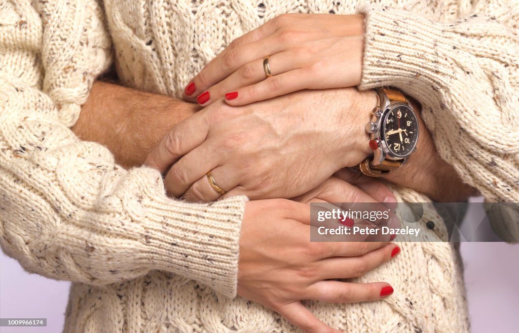 Husbands arms around pregnant wife's waist