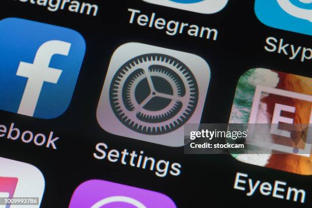 settings, facebook, eyeem and other phone apps on iphone screen - eyeem stock pictures, royalty-free photos & images