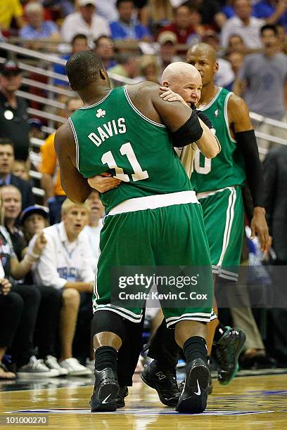Referee Joey Crawford holds up Glen Davis of the Boston Celtics due to Davis being disoriented after he took an elbow to the head from Dwight Howard...