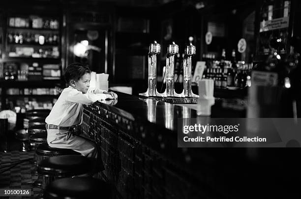 boy sitting alone at soda fountain - soda fountain stock pictures, royalty-free photos & images