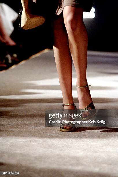 female legs walking on runway in gold heels - hoher absatz stock-fotos und bilder