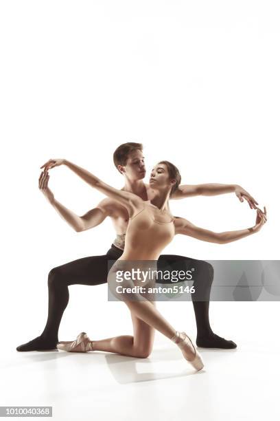 die beiden jungen modernen balletttänzer posieren über graue studio-hintergrund - turner contemporary stock-fotos und bilder