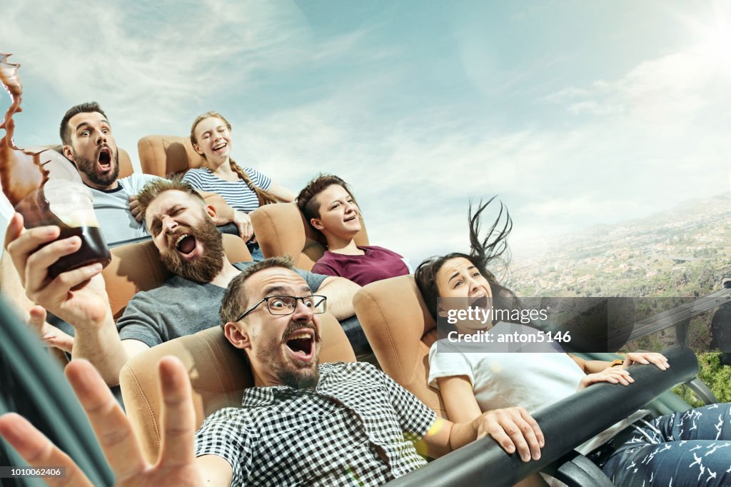 Die glücklichen Gefühle von Männern und Frauen, die gute Zeit auf einer Achterbahn im park