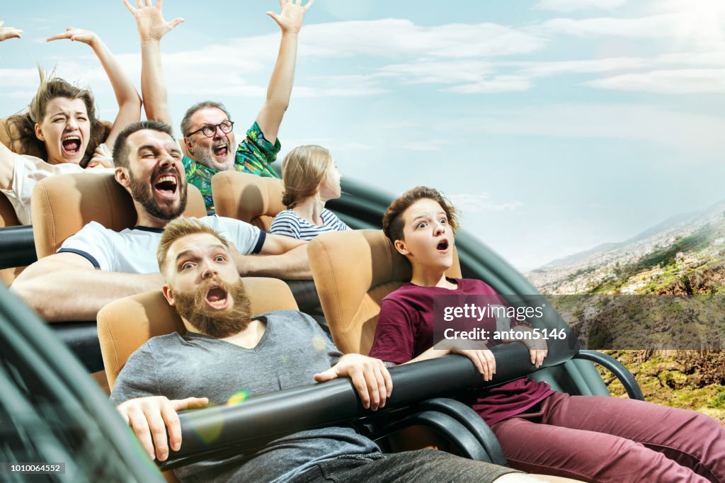 Die glücklichen Gefühle von Männern und Frauen, die gute Zeit auf einer Achterbahn im park