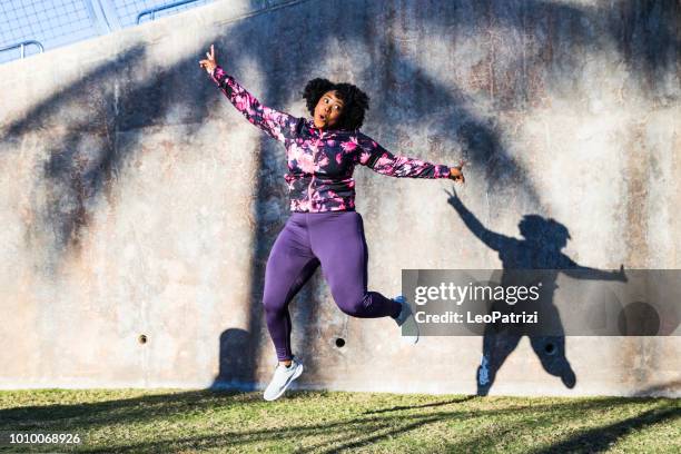 funny portrait of a young black curvy woman during a training session - exercise humour stock pictures, royalty-free photos & images