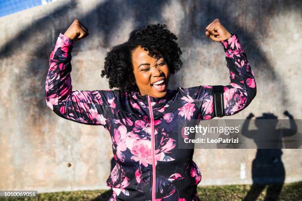 divertido retrato de una joven mujer de negra con curvas durante una sesión de entrenamiento - portrait image fotografías e imágenes de stock