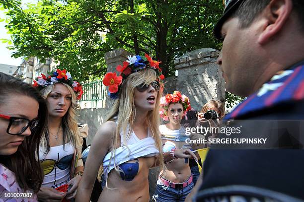 Policemen arrest activists of Ukrainian feminist movement 'Femen' who painted their breast blue in front of the Russian embassy in Kiev on May 27,...