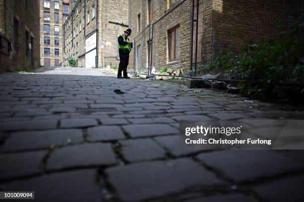 Police officer stands guard at the rear of the property of a man arrested on suspicion of murder on May 27, 2010 in Bradford, England. West Yorkshire...
