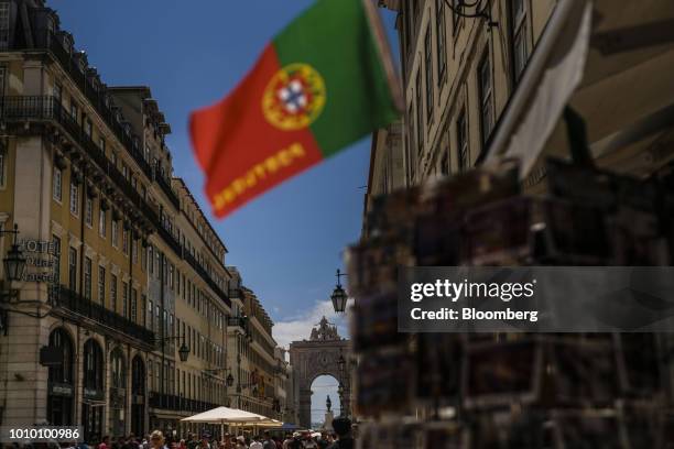 Portuguese national flag hangs on display outside a tourist store near the Augusta street arch in the Baixa district in Lisbon, Portugal, on Monday,...