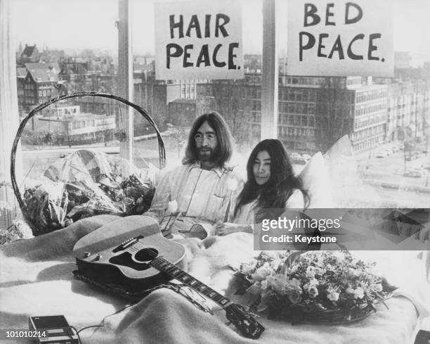 Week after their marriage, musicians John Lennon and Yoko Ono lay in their bed in the Presidential Suite of the Hilton Hotel, Amsterdam, 25th March...