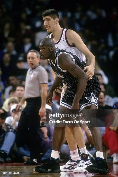 S: Center Shaquille O'Neal of the Orlando Magic is guarded closely by Gheorghe Muresan of the Washington Bullets circa mid 1990's during an NBA...