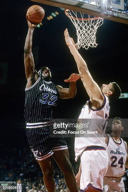 S: Center Shaquille O'Neal of the Orlando Magic shoots over Gheorghe Muresan of the Washington Bullets circa mid 1990's during an NBA basketball game...