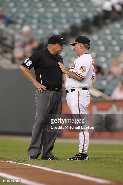 Dave Trembley, manager of the Baltimore Orioles, dicusses a call with first base umpire Mark Carlson during a baseball game against the Oakland...