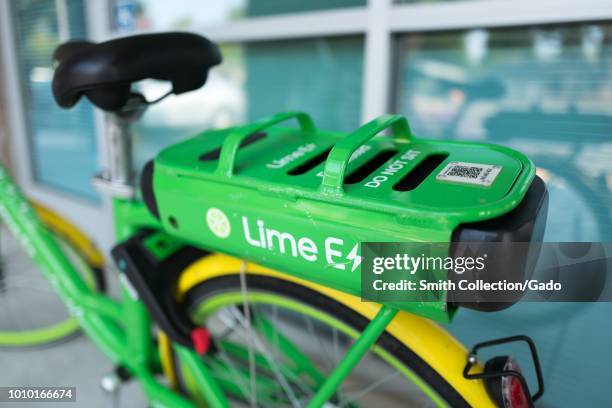 Close-up of rear fender and battery module on dockless electric bicycle from sharing economy startup Lime, branded as the Lime E-Bike, parked in a...