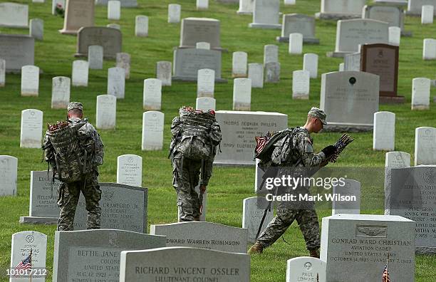 Members of the U.S. Army Old Guard place flags at gravesites at Arlington National Cemetery May 27, 2010 in Arlington, Virginia. It took 1,300...