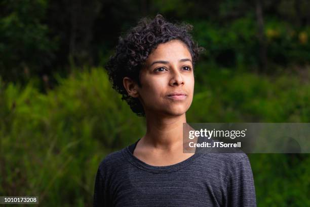 serene woman in lush outdoor setting - determination face stock pictures, royalty-free photos & images