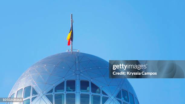 belgian flag on top of the atomium - brussels, belgium - atomium monument stock pictures, royalty-free photos & images