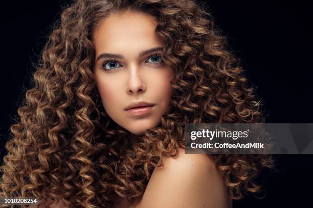 beautiful model with long curly hair - curly wig stock pictures, royalty-free photos & images