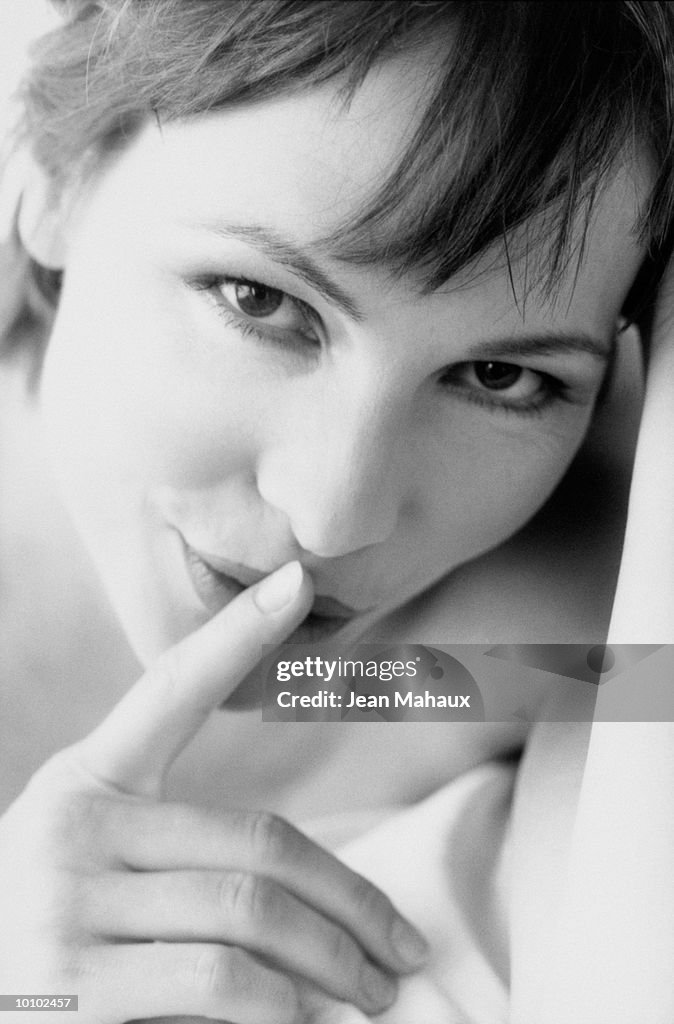 WOMAN WITH FINGER ON LIP