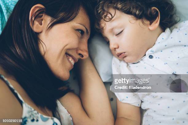 madre busca a su niño para dormir - sleeping toddler bed fotografías e imágenes de stock