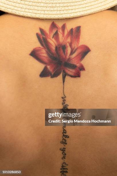a young woman's back with a lotus flower tattoo - mexican tattoo art fotografías e imágenes de stock