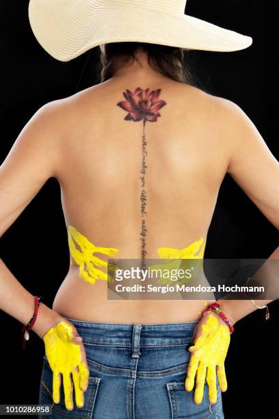 A Young Womans Back With A Lotus Flower Tattoo And Her Hands With Paint  High-Res Stock Photo - Getty Images