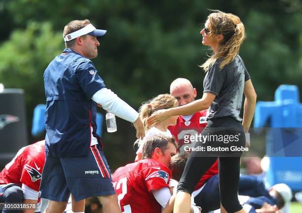 Gisele Bundchen, wife of Patriots quarterback Tom Brady, greets offensive coordinator Josh McDaniels following New England Patriots training camp at...