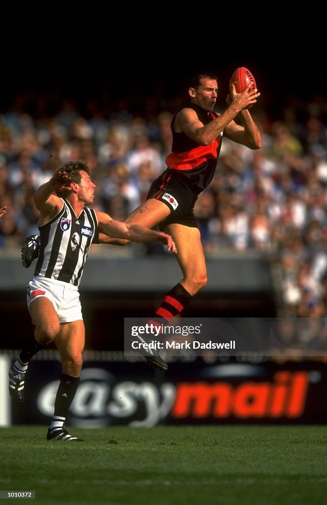 25 Apr 1999:  (L to R) Simon Eastaugh of the Essendon Bombers comes off second best in this battle w