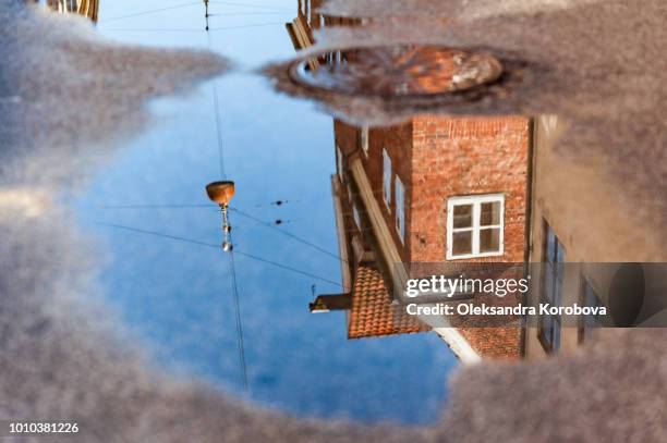 scenic summer view of elegant european building facades reflected in rain puddles on the ground. - copenhagen skyline stock pictures, royalty-free photos & images