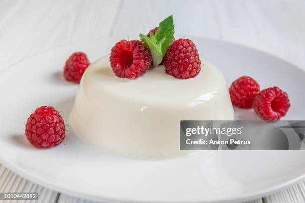 panna cotta with raspberry, decorated with fresh mint - panna cotta photos et images de collection