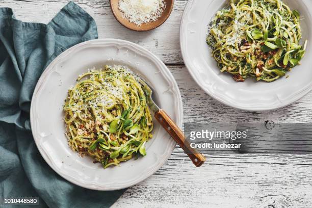 spaghetti mit gemüse, spinat und parmesan - rustic plate overhead stock-fotos und bilder