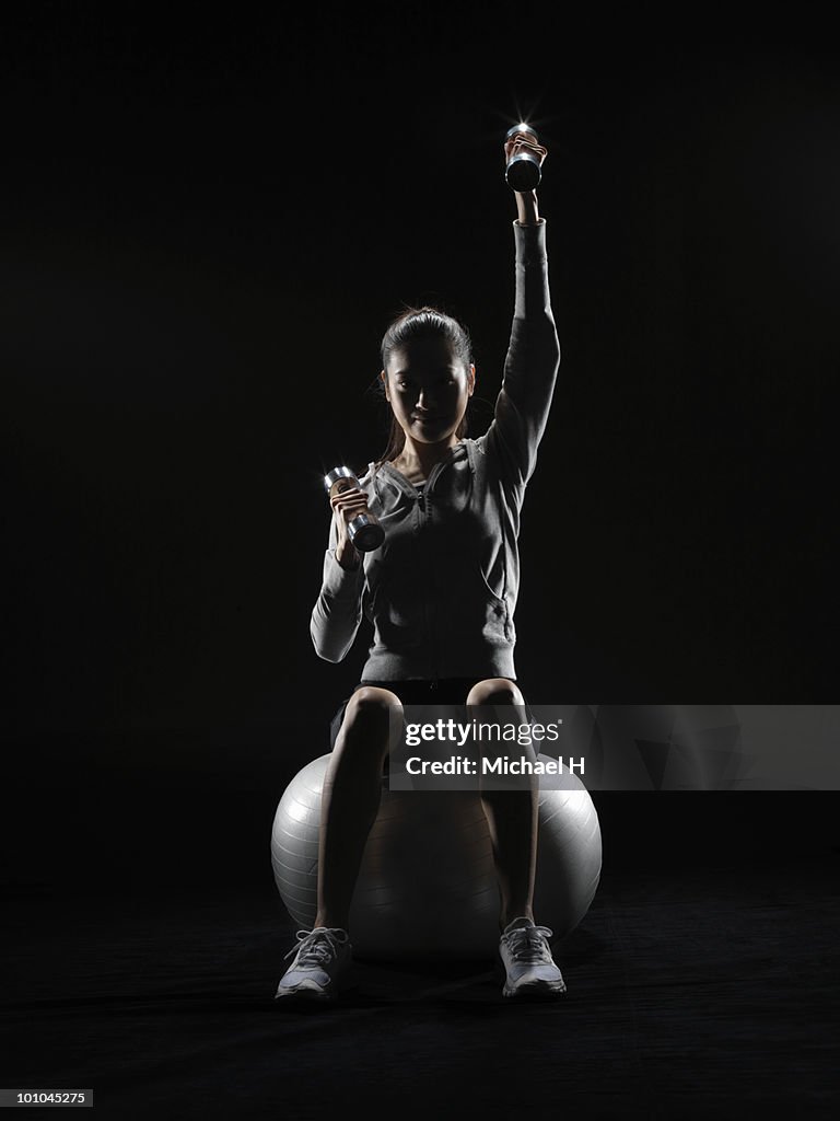 Woman who does weight training with balance ball