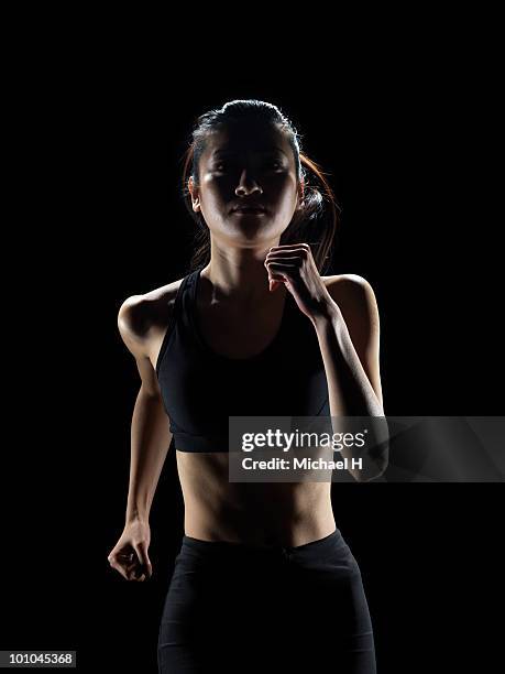 jogging female athlete - アスリート　黒背景 ストックフォトと画像