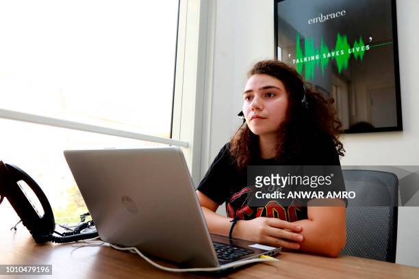 Sally, a volunteer, listens to a caller at Embrace, a suicide prevention helpline, in the Lebanese capital Beirut on July 13, 2018. - In Lebanon,...