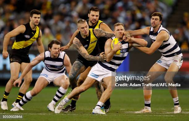Joel Selwood of the Cats is tackled high by Dustin Martin of the Tigers ahead of Patrick Dangerfield and Ryan Abbott of the Cats and Trent Cotchin...