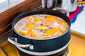 Cooking of oranges piece chewing with seasoning soup in pot