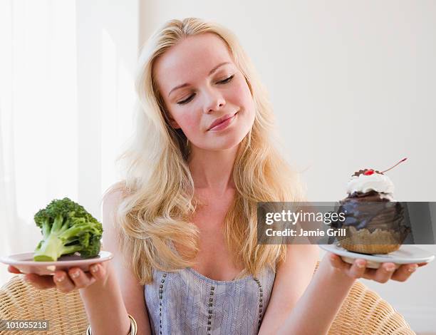 woman choosing between broccoli or sundae - temptation stock pictures, royalty-free photos & images