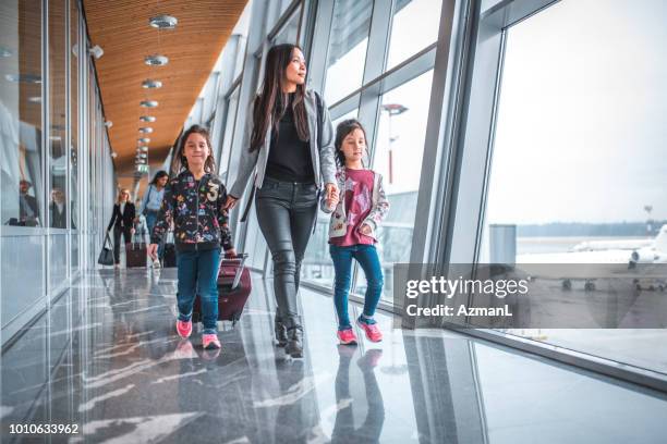 family walking by window at airport terminal - family airport stock pictures, royalty-free photos & images