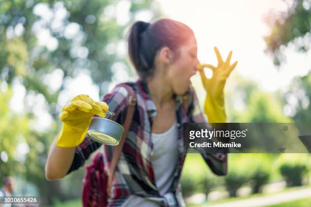 若い女性が公園で臭いこみを掃除 - 鼻をつまむ ストックフォトと画像