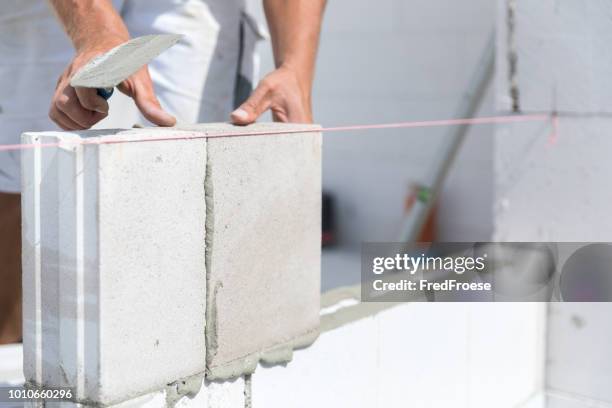 arbeiter auf der baustelle - bauarbeiter stock-fotos und bilder