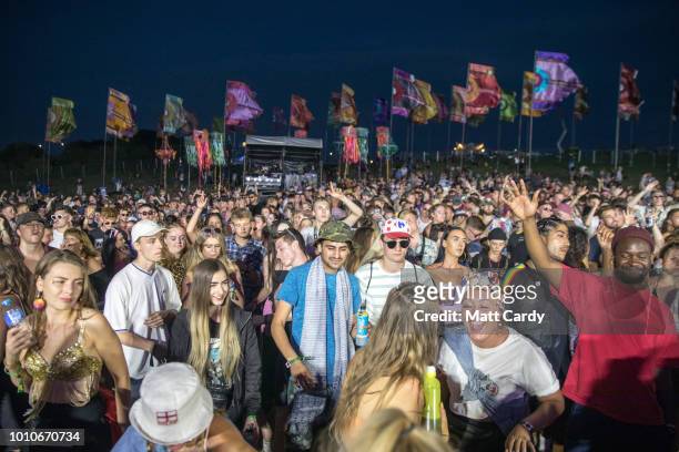 People dance as they listen to a DJ playing at the Temple stage at Bestival, at Lulworth Castle near East Lulworth on August 3, 2018 in Dorset,...
