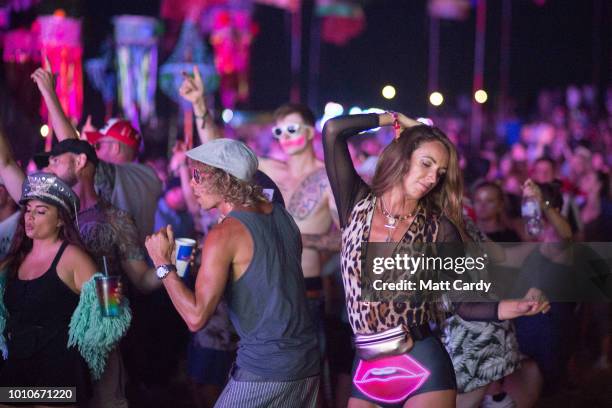 People dance as they listen to a DJ playing at the Temple stage at Bestival, at Lulworth Castle near East Lulworth on August 3, 2018 in Dorset,...