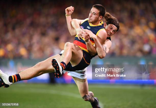 Luke Brown of the Adelaide Crows tackled over the boundary by Jasper Pittard of Port Adelaide during the round 20 AFL match between the Adelaide...