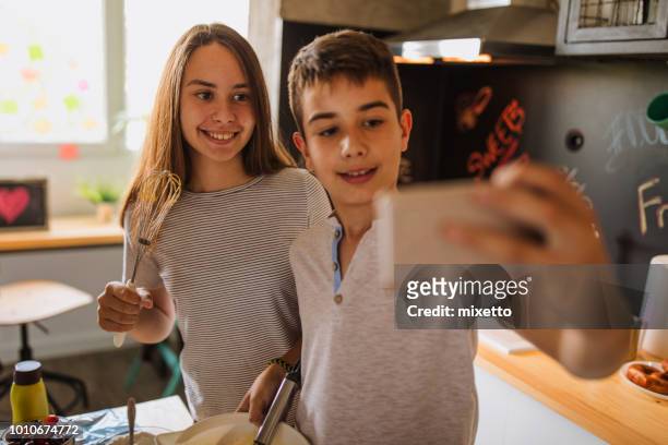 selfie in der küche - bruder schwester kochen stock-fotos und bilder