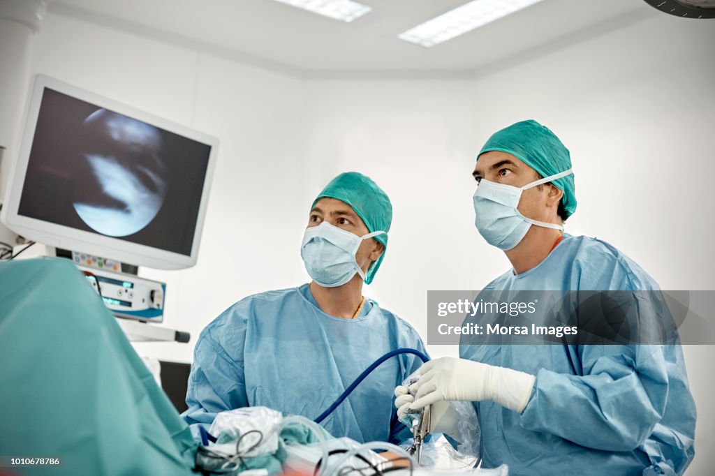 Surgeon Using Monitor Low Angle View Of Surgeons Looking At Monitor During Arthroscopy High ...